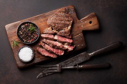 grilled-beef-steak-with-spices-on-cutting-board-PBRZYAX.jpg